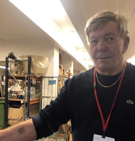 Henning viser stolt sin Knæk Cancer tatovering, som han fik lavet for et par år siden.